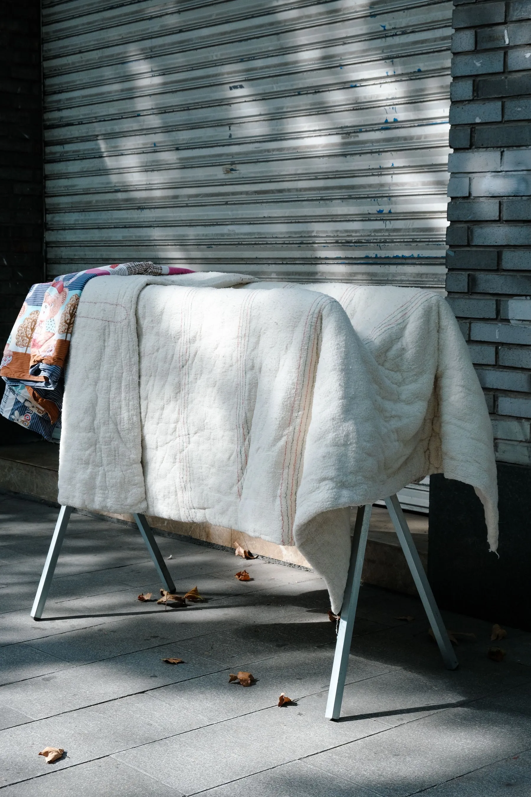 A quilted blanket draped over a drying frame to air-dry, with no pins